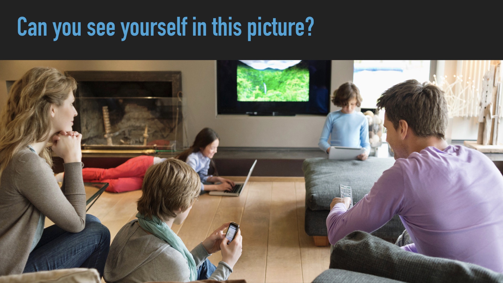 Image from a broadband ad showing aa white family in a living room, three kids each with their own device, dad with a remote pointed at the TV,mom staring vaguely off into space. Headline (from me): can you see yourself in this picture?
