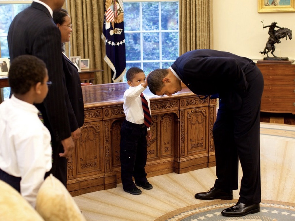 Slide 39: Obama leaning over inthe oval office to let a small african american boy touch his hair.