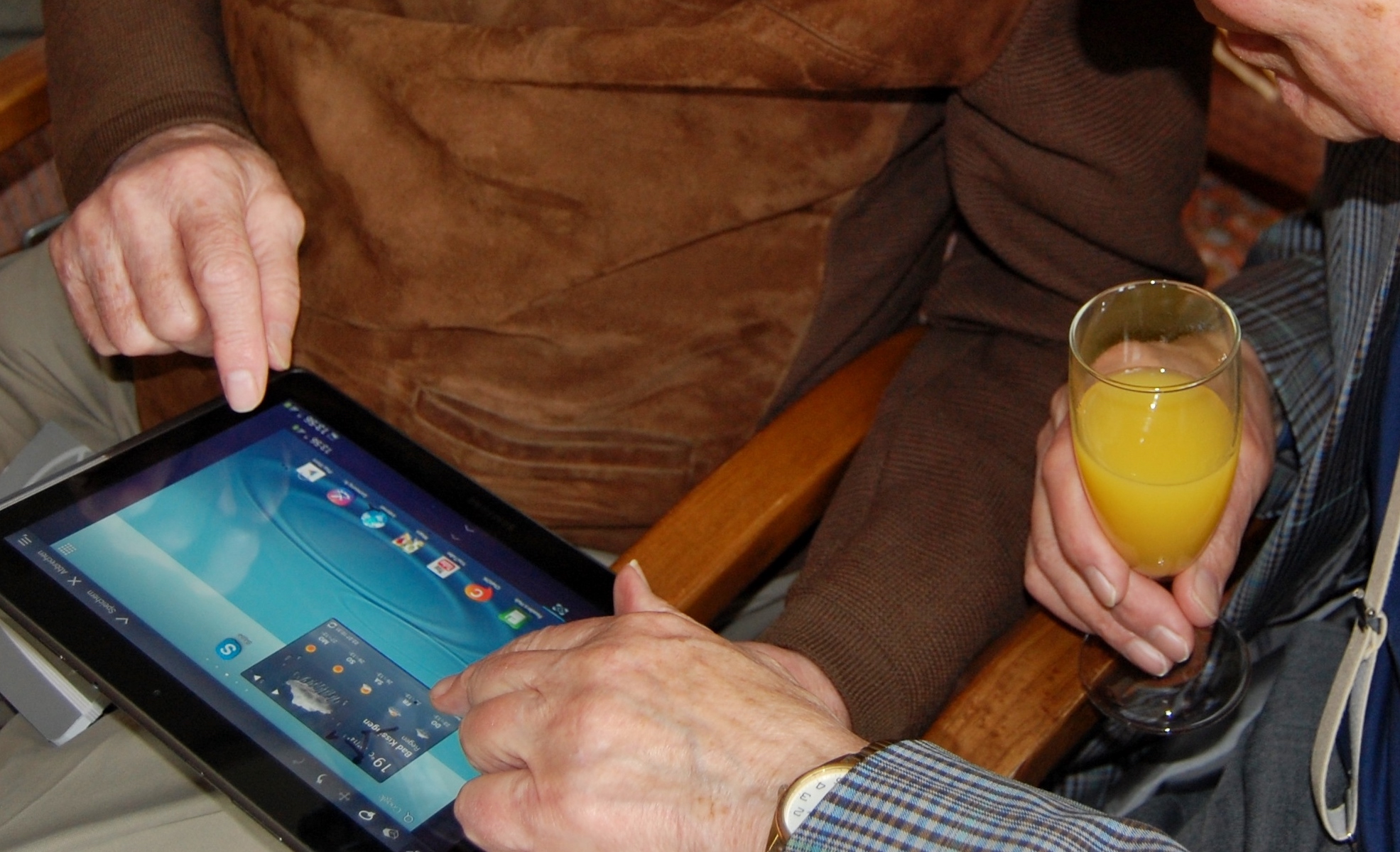 hands of two men using a tablet computer